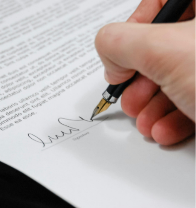 An image of someone signing a contract to acquire their new home.